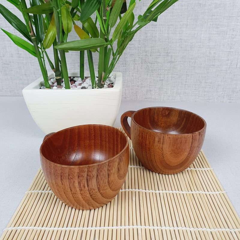 Bamboo coffee cups with plant in white planter.